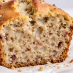 A whole loaf of cottage cheese banana bread with a golden crust on parchment paper.