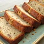 Moist slices of cottage cheese banana bread stacked neatly on a ceramic plate.