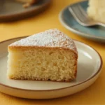 Delicious slice of lemon ricotta cake on a plate with powdered sugar, showing tender crumb.