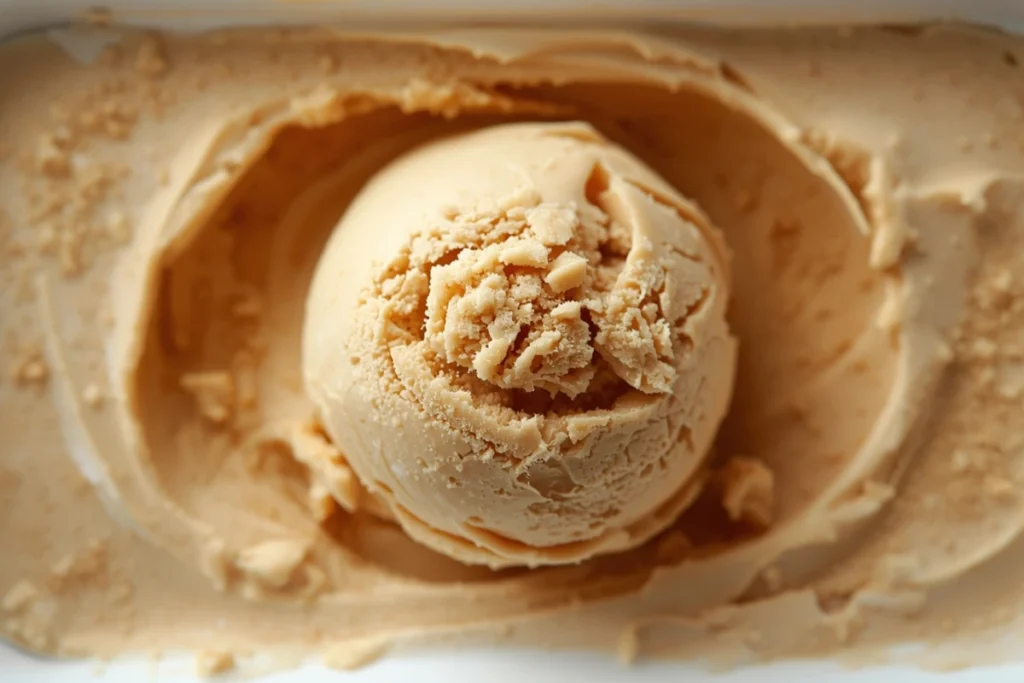 Large scoop of homemade peanut butter ice cream in a white container, showcasing the creamy texture from our recipe.
