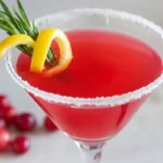 Cranberry lemon drop cocktail with a sugared rim and fresh rosemary garnish.